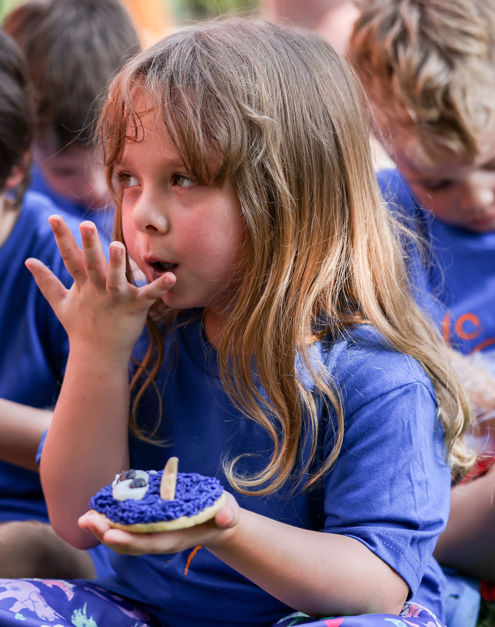 Evelyn Shindledecker eats a cookie during a ceremony celebrating an outdoor playground at Rainbow Years Child Care on South Smithville Road in Dayton on Wednesday, June 25. BRYANT BILLING / STAFF