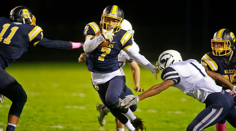 Springfield’s Daniel Davis avoids a tackle by Fairmont”s Marqies Williams as he carries the ball for a first down. Bill Lackey/Staff
