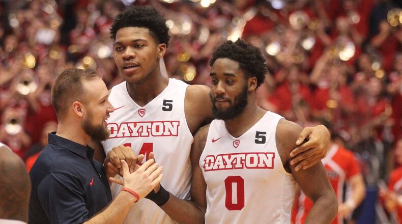 Dayton’s Casey Cathrall, left, congratulates Josh Cunningham after his game-winning basket against Ball State on Friday, Nov. 10, 2017, at UD Arena. At center is Jordan Pierce. David Jablonski/Staff