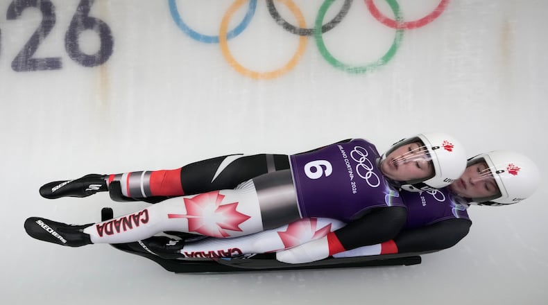 Canada's Beattie Podulsky, left, and Kailey Allan, right, slide down the track during a women's doubles luge training session at the 2026 Winter Olympics, in Cortina d'Ampezzo, Italy, Sunday, Feb. 8, 2026. (AP Photo/Aijaz Rahi)