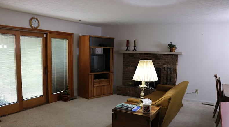 Kitchen, dining area and family room flow easily together for casual entertaining with a brick fireplace serving the entire gathering space.