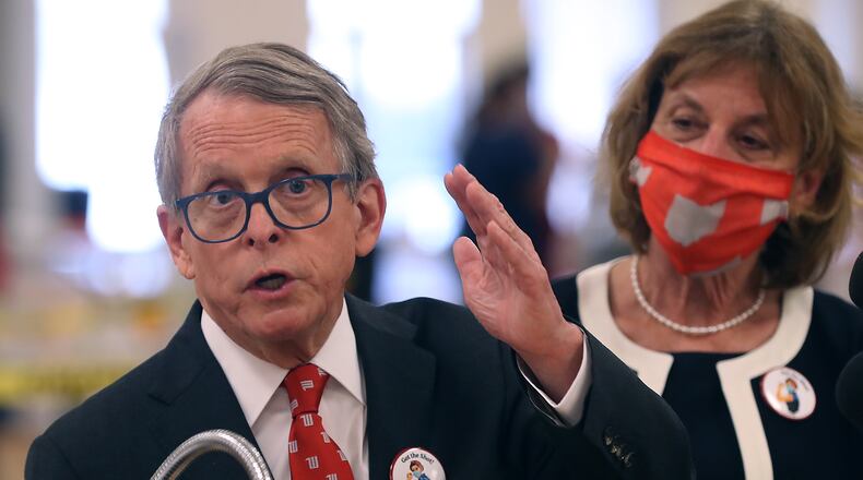 Governor Mike DeWine speaks to the media after touring the Clark County COVID vaccine distribution center with his wife, Fran, at the Upper Valley Mall. BILL LACKEY/STAFF