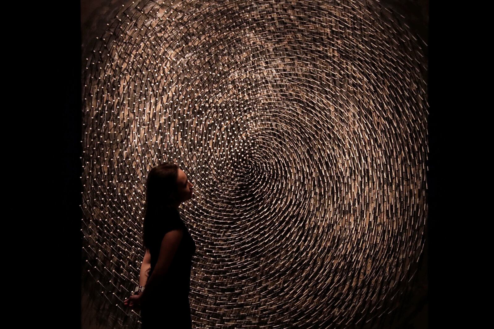 FILE - A Christie's auction house employee poses for photographs next to one part of German Sculptor's Guenther Uecker's "Spirale I, Spirale II (Doppelspirale)" at their premises in London, Friday, March 3, 2017. (AP Photo/Matt Dunham, File)