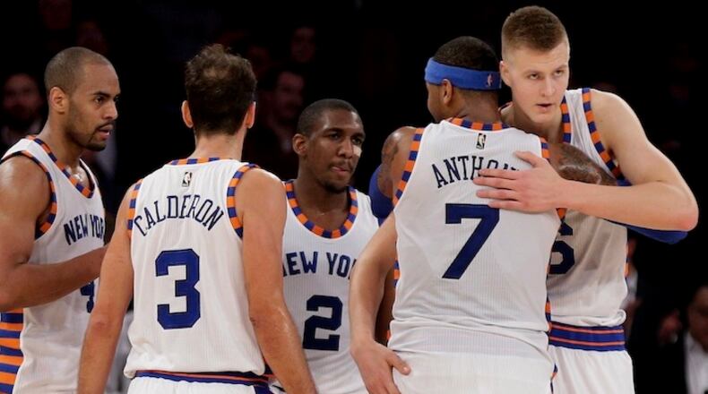 New York Knicks forward Carmelo Anthony (7) hugs New York Knicks forward Kristaps Porzingis (6) as they huddle with guard Arron Afflalo (4), guard Jose Calderon (3) and guard Langston Galloway (2) during the fourth quarter of an NBA basketball game against the Charlotte Hornets, Tuesday, Nov. 17, 2015, in New York. (AP Photo/Julie Jacobson)