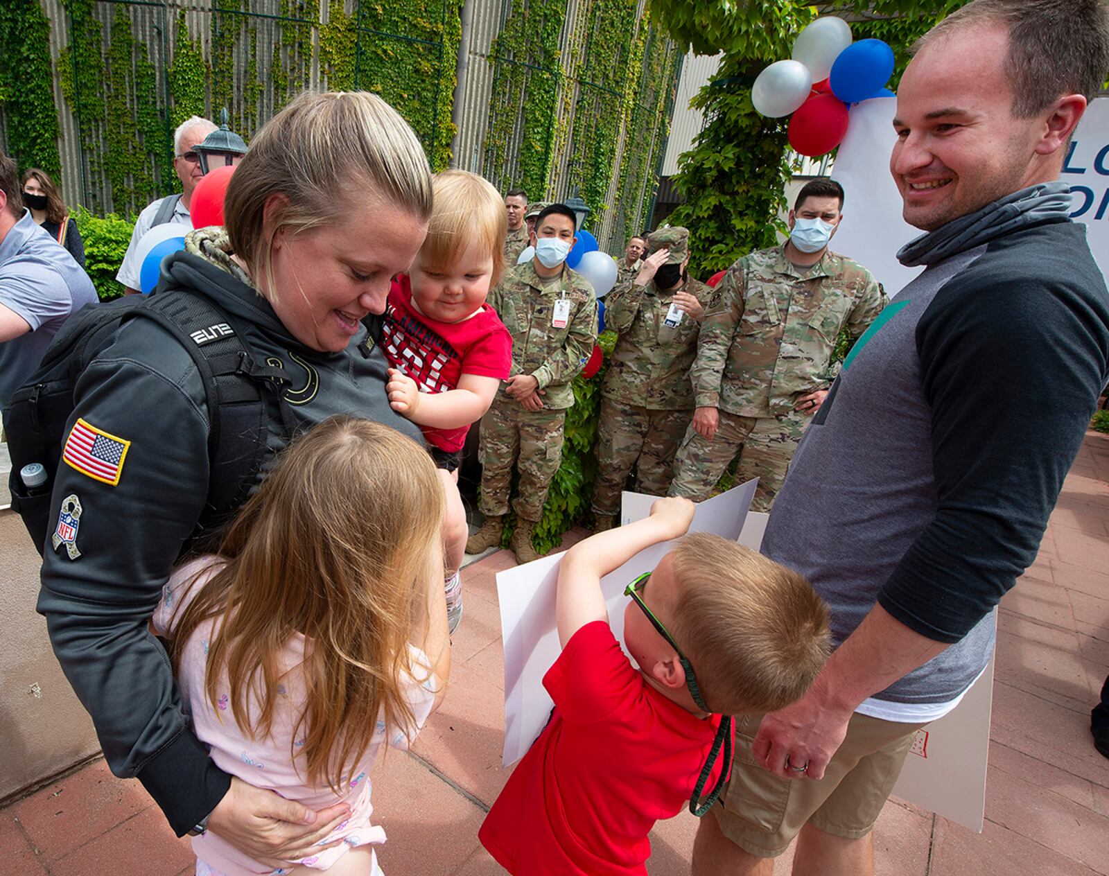Maj. Erica Eyer hugs her children – Isla, Reagan and Brent – shortly after she stepped off the bus May 18 at Wright-Patterson Medical Center, returning from a two-month deployment to Detroit. Eyer, a nurse with the 88th Operational Medical Readiness Squadron, was among nearly 120 Airmen who deployed to Detroit to help at a mass COVID-19 vaccination site. U.S. AIR FORCE PHOTO/R.J. ORIEZ