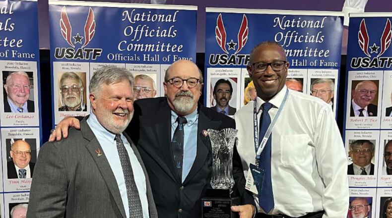 Mike Trego being honored with the USTAF John Davis award in 2023. This award is presented annually to recognize the humanitarian efforts of an official who provides leadership, sets an example, and goes out of their way to help in the development of others in the USATF officials organization. (left to right) Mike Armstrong is NOC chairman, Trego, and Jamero Rainey, Illinois Association member who presented the award. CONTRIBUTED