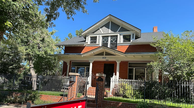 FILE - A for sale sign stands outside a home on the market in the Alamo Placita neighborhood Tuesday, Aug. 27, 2024, in central Denver. (AP Photo/David Zalubowski, File)