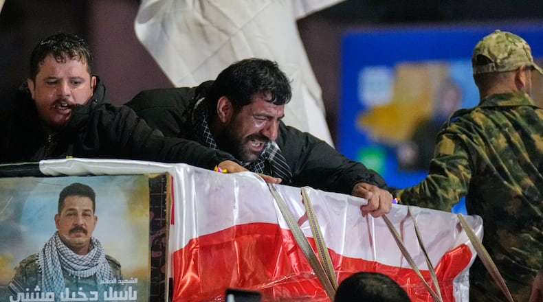 Relatives grieve in Baghdad, Iraq, on Thursday, March 12, 2026, during a funeral for members of the Popular Mobilization Forces who were killed in a U.S. airstrike in Qaim. (AP Photo/Hadi Mizban)
