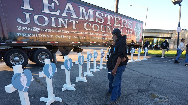 FILE - Allen Wilson, right, hugs an attendee after they wrote on crosses for victims during a vigil Thursday, Nov. 6, 2025, in Louisville, Ky., after a UPS plane crashed at Louisville Muhammad Ali International Airport. (AP Photo/Darron Cummings, File)