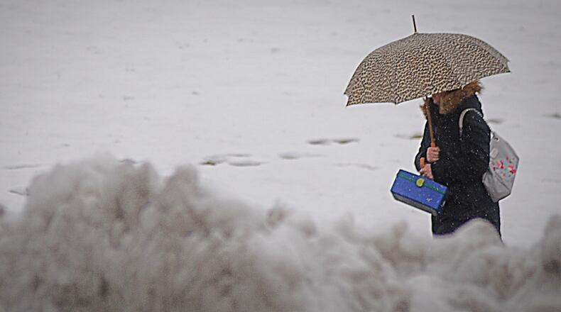 A woman tries to stay dry on a cold and windy day in January in Huber Heights. Photo Marshall Gorby