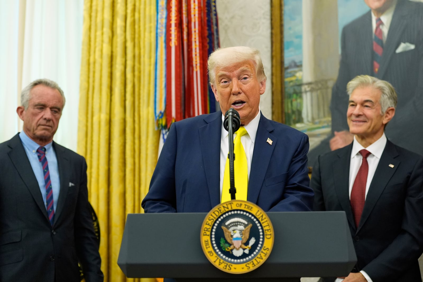 FILE - President Donald Trump speaks as Health and Human Services Secretary Robert F. Kennedy Jr., left, and Dr. Mehmet Oz, right, listen during a swearing in ceremony for Oz to be Administrator of the Centers for Medicare and Medicaid Services, in the Oval Office of the White House, April 18, 2025, in Washington. (AP Photo/Alex Brandon, File)