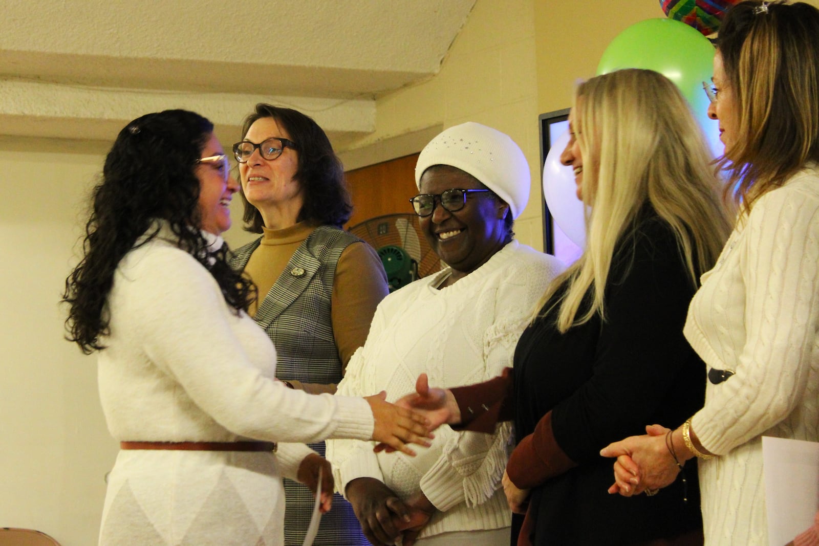 Catherine Bitwayiki grins at a graduate of her nonprofit's community health worker program during a celebration on Wednesday, Dec. 10, 2025.