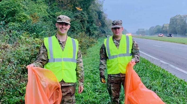 Staff Sgt. Zachary Penrod (left) and Airman 1st Class Matthew Ridenour join together to collect trash Oct. 7 from one side of state Route 444. CONTRIBUTED PHOTO