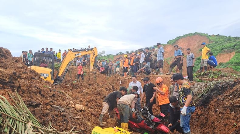 In this photo released on Saturday, Nov. 29, 2025 by the Indonesian National Search and Rescue Agency (BASARNAS), rescuers remove a scooter buried in the mud as they search for victims at a village hit by a landslide in Batu Goading, North Sumatra, Indonesia. (BASARNAS via AP)