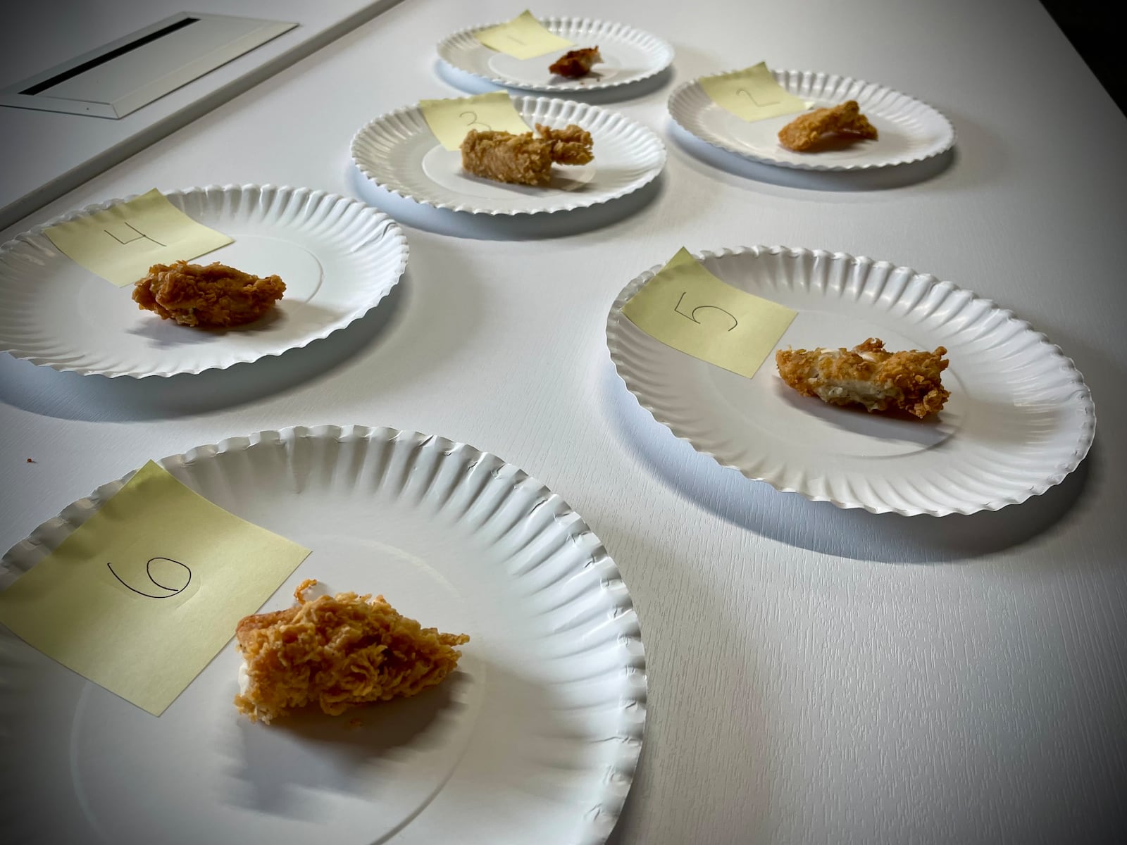 Each chicken tender was broken into bite-size pieces, placed on a paper plate and numbered one through six. Each person had to guess which chicken tender was from which restaurant. NATALIE JONES/STAFF
