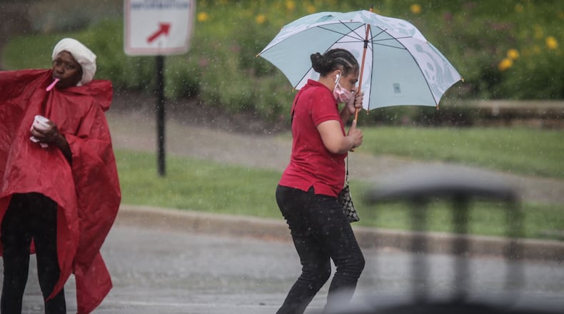 FILE PHOTO: Two people run in the rain in Dayton. JIM NOELKER / STAFF