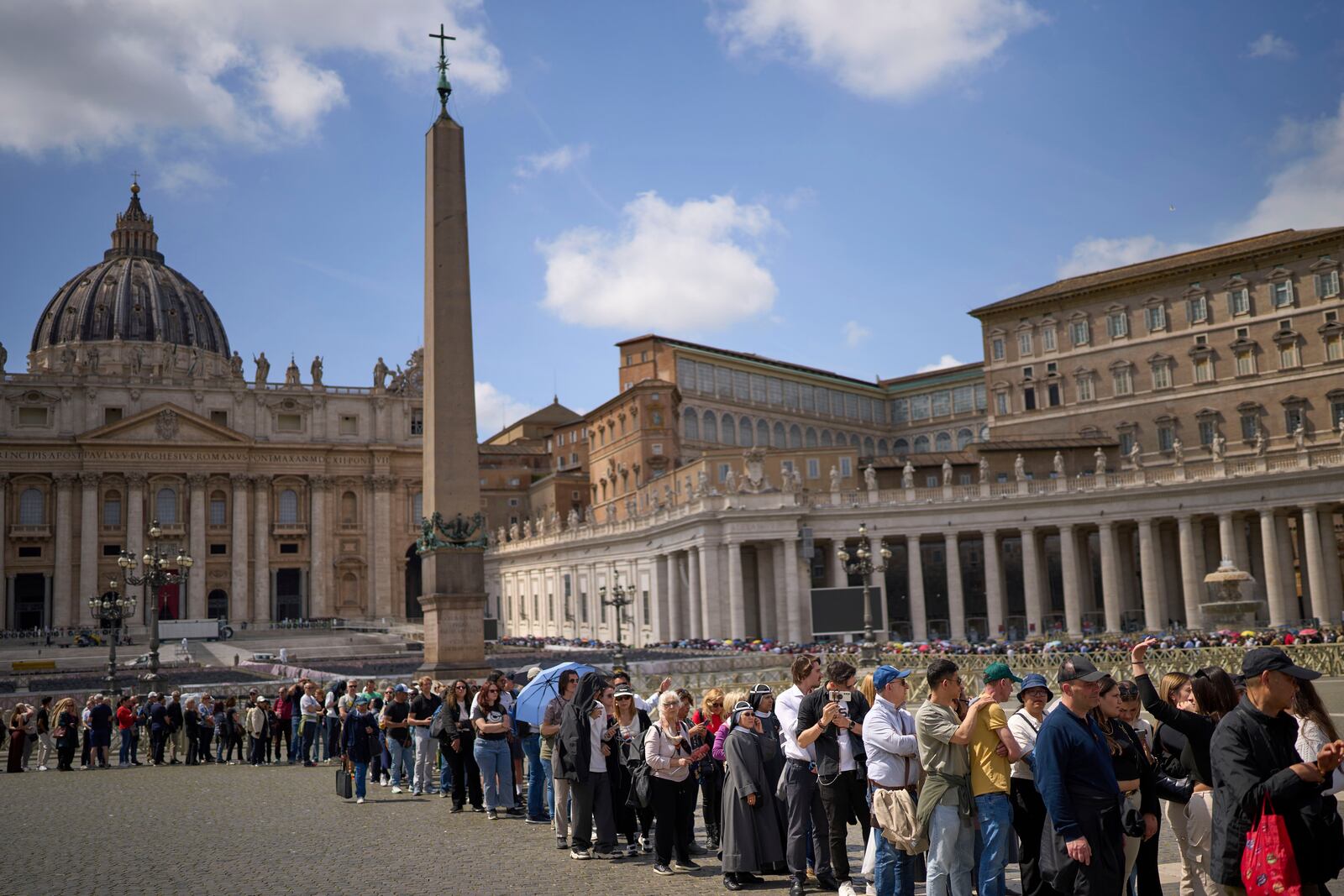 People queue in St. Peter's Square to pay their respect to the late Pope Francis, who will lie in state at St. Peter's Basilica for three days, at the Vatican, Wednesday, April 23, 2025. (AP Photo/Emilio Morenatti)
