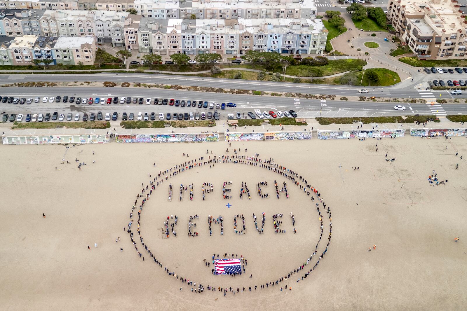 Protesters form a "Impeach & Remove" human banner on Ocean Beach during a protest against U.S. President Donald Trump, in San Francisco, Saturday, April 19, 2025. (Stephen Lam/San Francisco Chronicle via AP)
