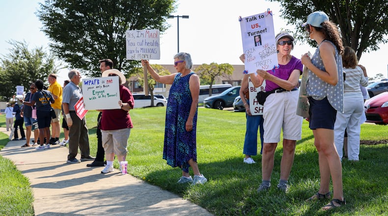 Demonstrators gathered on Thursday on the sidewalk along Presidential Drive in Fairborn near Wright State University in front of a DoubleTree by Hilton that U.S. Rep. Mike Turner (R-Dayton) was scheduled to speak at during a meeting with a defense trade group. Demonstrators were holding signs criticizing Turner for not hosting town halls or public meetings. BRYANT BILLING / STAFF
