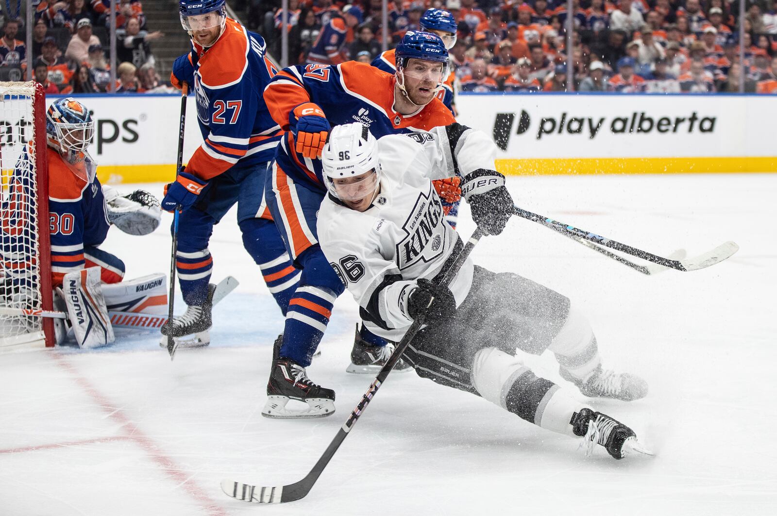 Los Angeles Kings' Andrei Kuzmenko (96) and Edmonton Oilers' Connor McDavid (97) battle for the puck during the third period of an NHL hockey playoff game in Edmonton, Alberta, Friday, April 25, 2025. (Jason Franson/The Canadian Press via AP)