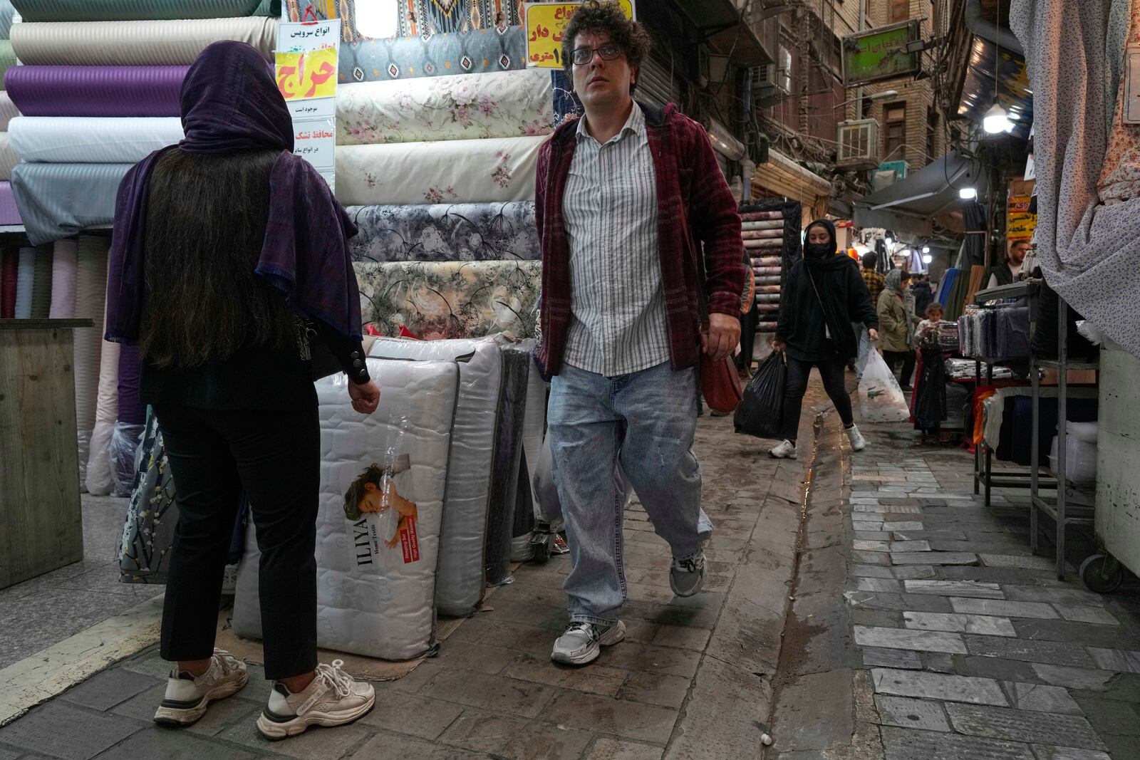 People walk through the old grand bazaar of Tehran, Iran, Saturday, April 5, 2025. (AP Photo/Vahid Salemi)