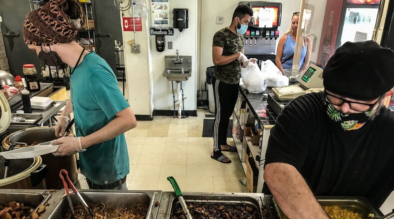 Bourbon Street Grill & Cafe employees from left, Bobby Lauer, Aissa Ouland and Scott Freeman make food for walk in customers at the restaurant on Brown Street in Dayton. Owner, Hassan Abdalla said, “we never closed and never laid-off anyone.” JIM NOELKER/STAFF