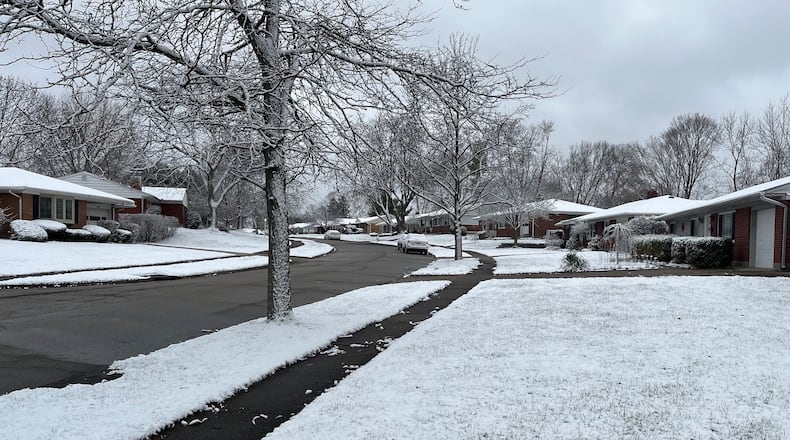 Light snow covers the yards of a Kettering street on Sunday, March 12, 2023, the day to "spring forward" into daylight saving time on the clock.