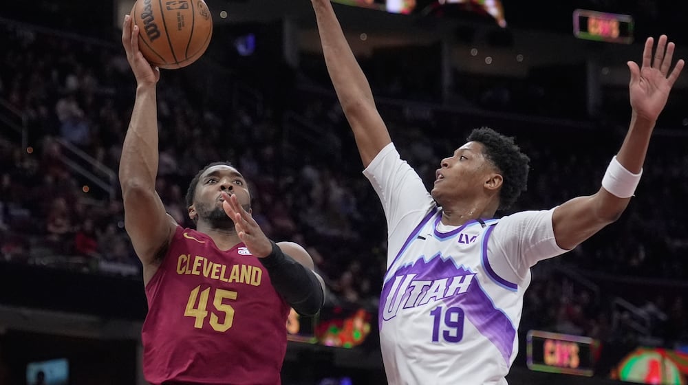 Cleveland Cavaliers guard Donovan Mitchell (45) shoots next to Utah Jazz guard Ace Bailey (19) in the second half of an NBA basketball game in Cleveland, Monday, Jan. 12, 2026. (AP Photo/Sue Ogrocki)