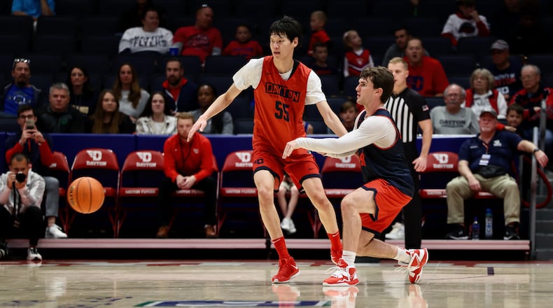 Dayton's Brady Uhl passes around Mike Sharavjamts at the Red & Blue Game on Saturday, Oct. 15, 2022, at UD Arena. David Jablonski/Staff