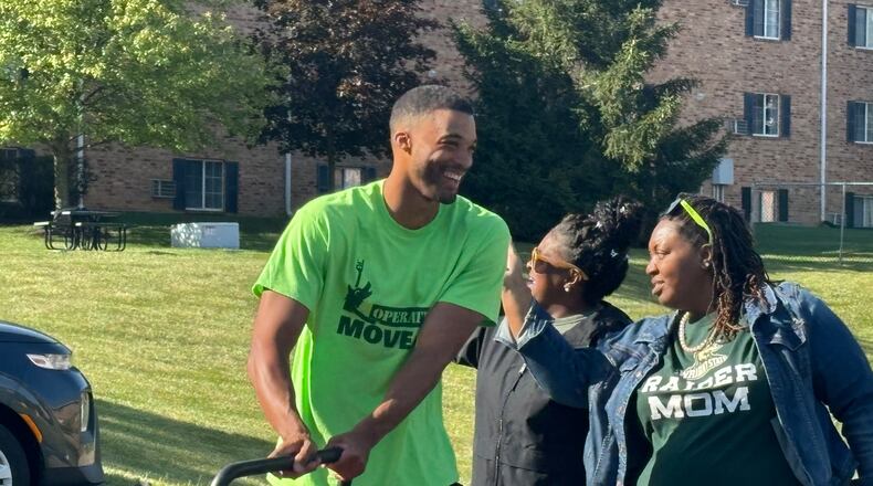 Volunteers helped unload cars and move students into residence halls as Debra Radford, left and Franchesca Alford, right, cheered for them on Wednesday morning. Eileen McClory/ staff
