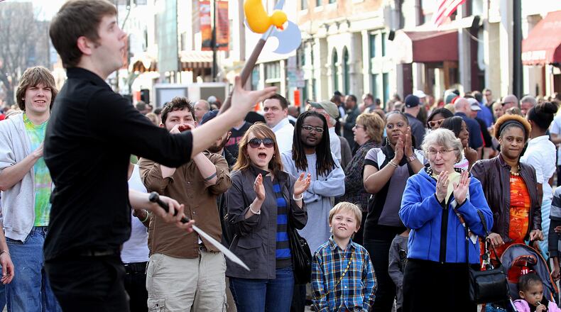 E.L. Hubbard photography People watch a street performer during the NCAA First Four Festival in downtown Dayton's Oregon District Sunday, March 11, 2012. Big Hoopla, a volunteer based non-profit that organizes local activities around the NCAA First Four and the Division I Men’s Basketball Tournament held at the University of Dayton, and the Oregon District Business Association will hold a family-friendly festival 10 a.m. to 8 p.m. March 15, 2020.