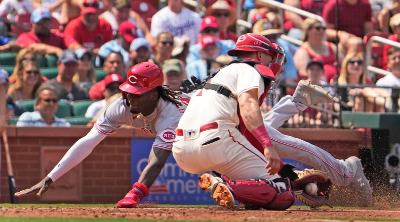 Cincinnati Reds' Elly De La Cruz, left, scores past St. Louis Cardinals catcher Andrew Knizner during the seventh inning of a baseball game Saturday, June 10, 2023, in St. Louis. (AP Photo/Jeff Roberson)