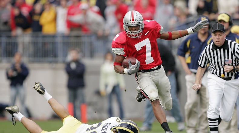 COLUMBUS, OH - NOVEMBER 20: Defensive back Ted Ginn Jr. #7 of the Ohio State Buckeyes runs around punter Adam Finley #39 of the Michigan Wolverines for an 82-yard touchdown return during the third quarter on November 20, 2004 at Ohio Stadium in Columbus, Ohio. Ohio State upset Michigan 37-21. (Photo by Brian Bahr/Getty Images)