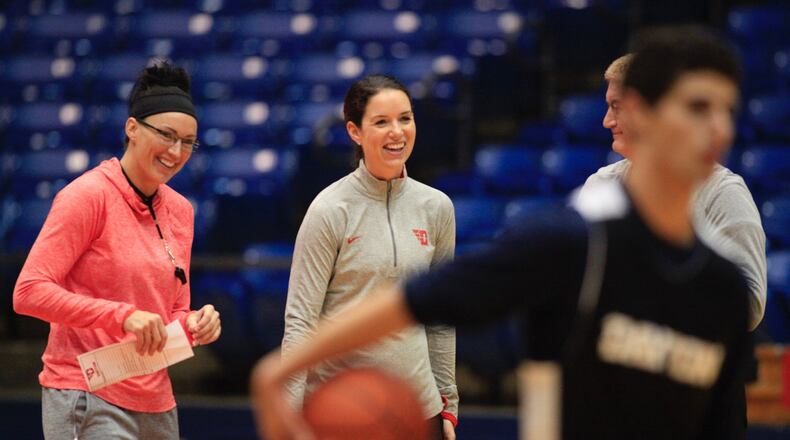 Dayton coaches Kayla Ard, left, Shauna Green, center, and Jeff House, back right, watch practice at UD Arena on Tuesday, Oct. 11, 2016. David Jablonski/Staff