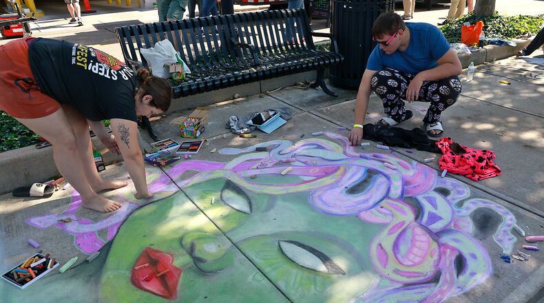 Journey Armstrong and Charlie Scott work on their chalk art Saturday, Oct. 5, 2024 during ChalkFest at National Road Commons Park in downtown Springfield. Dozens of amateur and professional artists from around the area showed off their skill on the sidewalks and streets around the park. ChalkFest also featured live music, food trucks and creative activities for the kids. BILL LACKEY/STAFF