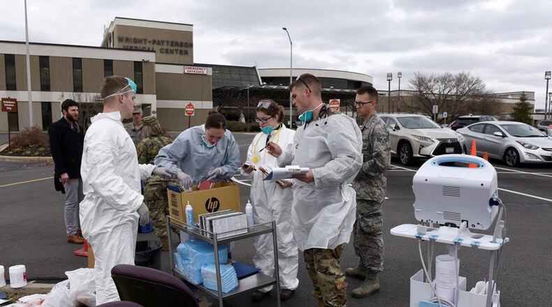 Air Force personnel prepare to screen patients in front of the Wright-Patterson Medical Center March 16. The 88th Medical Group staff began screening patients before they entered the medical center as part of the COVID-19 protocol instituted at the facility. (U.S. Air Force photo/Ty Greenlees)