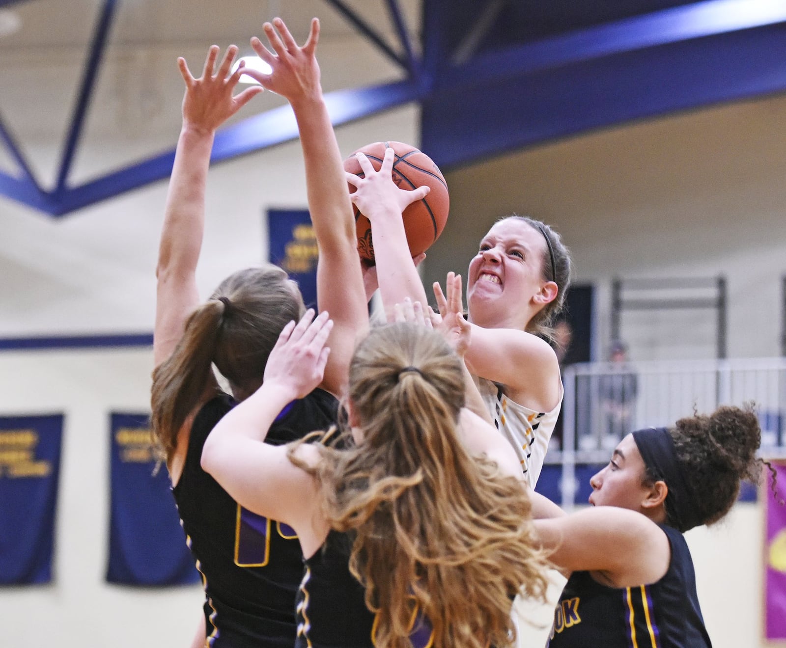 Monroe’s Sophie Sloneker puts up a shot over a group of Bellbrook defenders during Thursday night’s game at Monroe. NICK GRAHAM/STAFF