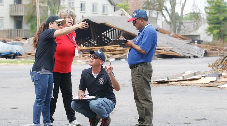 From left, Malyssa Suarez, with the Federal Emergency Management Agency (FEMA), Brigitte Bouska, with the Ohio Emergency Management Agency, Steve Cooper, of FEMA, and Ahmed Hossain, of the Small Business Administration, conduct a joint preliminary assessment of tornado damage Wednesday, June 5, at the Woodland Hills Apartments in Trotwood. CHRIS STEWART / STAFF