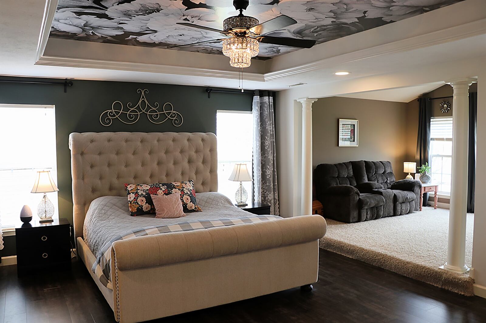 The main bedroom suite has a tray ceiling, wood flooring and tall windows that flank the bed’s headboard. Columns accent the open walkway to the sitting room, which is one step up from the bedroom. The sitting room has a cathedral ceiling and carpeting and media area. CONTRIBUTED PHOTO BY KATHY TYLER