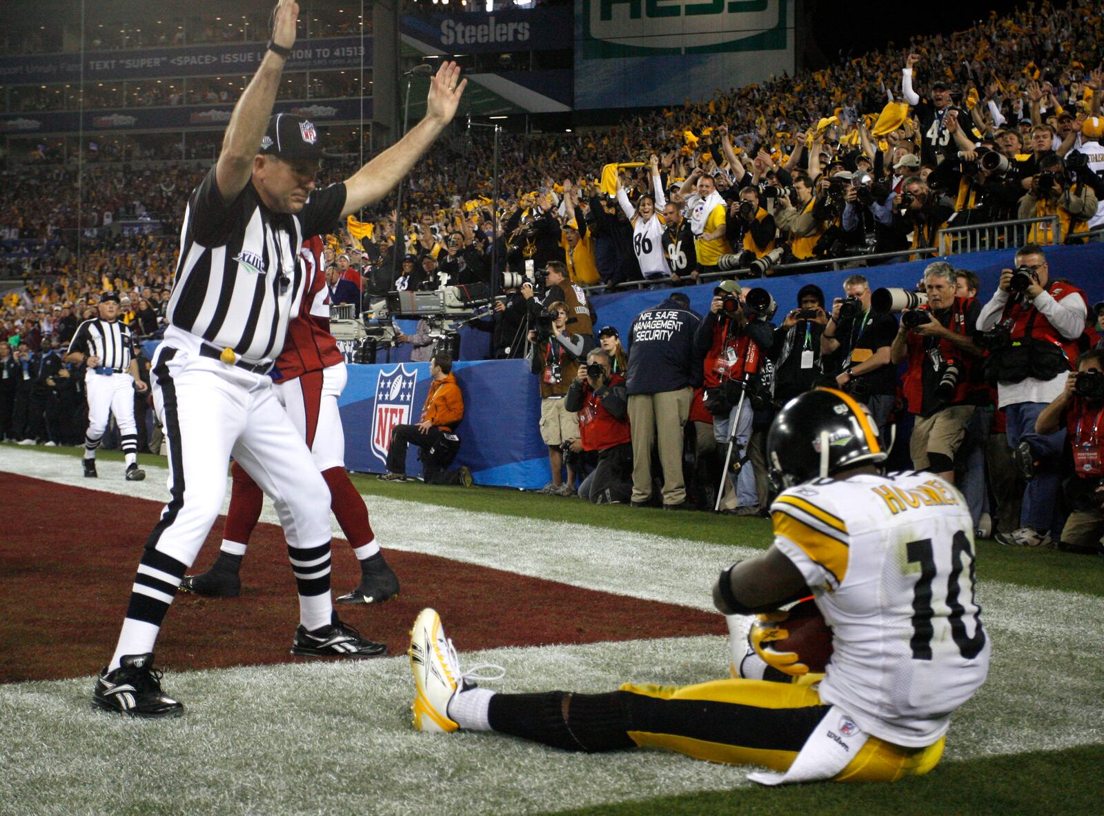 Field judge Greg Gautreaux raises his arms signaling a touchdown as Pittsburgh Steelers wide receiver Santonio Holmes (10) sits on the ground after scoring during the fourth quarter of the NFL Super Bowl XLIII football game against the Arizona Cardinals, Sunday, Feb. 1, 2009, in Tampa, Fla. The Steelers won 27-23. (Brian Cassella/Tampa Bay Times via AP, File)