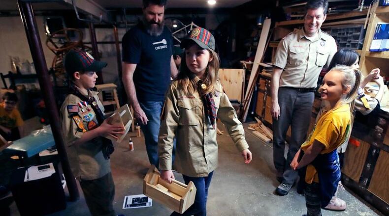 The Boy Scouts of America (BSA) announced that it will be undergoing a significant name change regarding its 108-year program. In this March 1, 2018, file photo, Tatum Weir, center, carries a tool box she built as her twin brother Ian, left, follows after a Cub Scout meeting in Madbury, N.H. Fifteen communities in New Hampshire are part of an “early adopter” program to allow girls to become Cub Scouts and eventually Boy Scouts. For 108 years, the Boy Scouts of America’s flagship program for older boys has been known simply as the Boy Scouts. With girls soon entering the ranks, the BSA says that iconic name will change to Scouts BSA. The change will take effect in February 2019. (AP Photo/Charles Krupa, File)