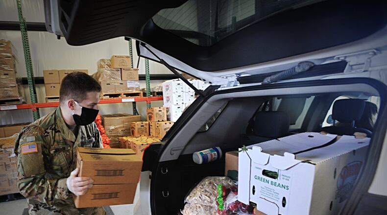 A member of the National Guard loads fresh food into the back of a vehicle at The Foodbank. MARSHALL GORBYSTAFF