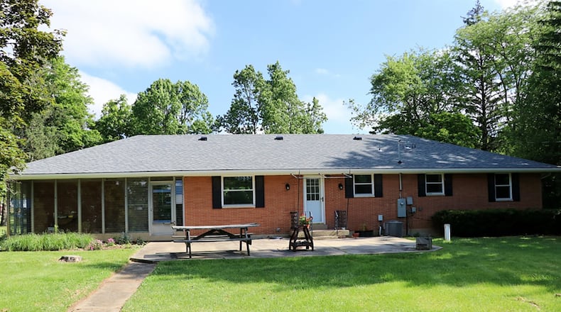 Sliding patio doors from the dining room open into a sunroom with screened-windows and access to the garage and rear patio. A door from the updated kitchen opens to the rear patio and tree-lined back yard.