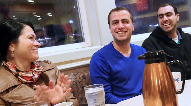 Dr. Mahmoud Dabbous, center, laughs as he and other local residents, including Dr. Gigi Sankary, left, and Ahmad Abbas, right, all originally from Syria celebrate together at the IHOP on Talmadge Road in West Toledo. A group of about 20 local residents, including many Syrian expatriates, meet weekly to get to know one another over coffee. Often they stay for hours, sometimes into the early morning, catching up with their new neighbors as they build community. On this particular Tuesday, the group was celebrating Dr. Dabbous’ news: he was cleared the begin the processes of certification to practice medicine in the U.S. Dr. Dabbous is general practitioner and Dr. Sankary is a dentist. Dr. Dabbous and Mr. Abbas have come America as an asylum-seekers, while Dr. Sankary is an American citizen, though her husband and children are not. The ongoing war in Syria has produced an international refugee crisis, and forced many of the country’s citizens to flee by other means, such as seeking asylum. The war has also divided families; Dr. Dabbous’ family continue to live in Syria, Dr. Sankary’s two adult daughters are stranded in Turkey and Mr. Abbas’ wife remains in Damascus. THE BLADE/KATIE RAUSCH