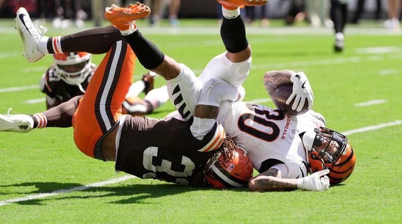 Cincinnati Bengals running back Chase Brown (30) is tackled by Cleveland Browns safety Ronnie Hickman (33) during the first half of an NFL football game Sunday, Sept. 7, 2025, in Cleveland. (AP Photo/Sue Ogrocki)
