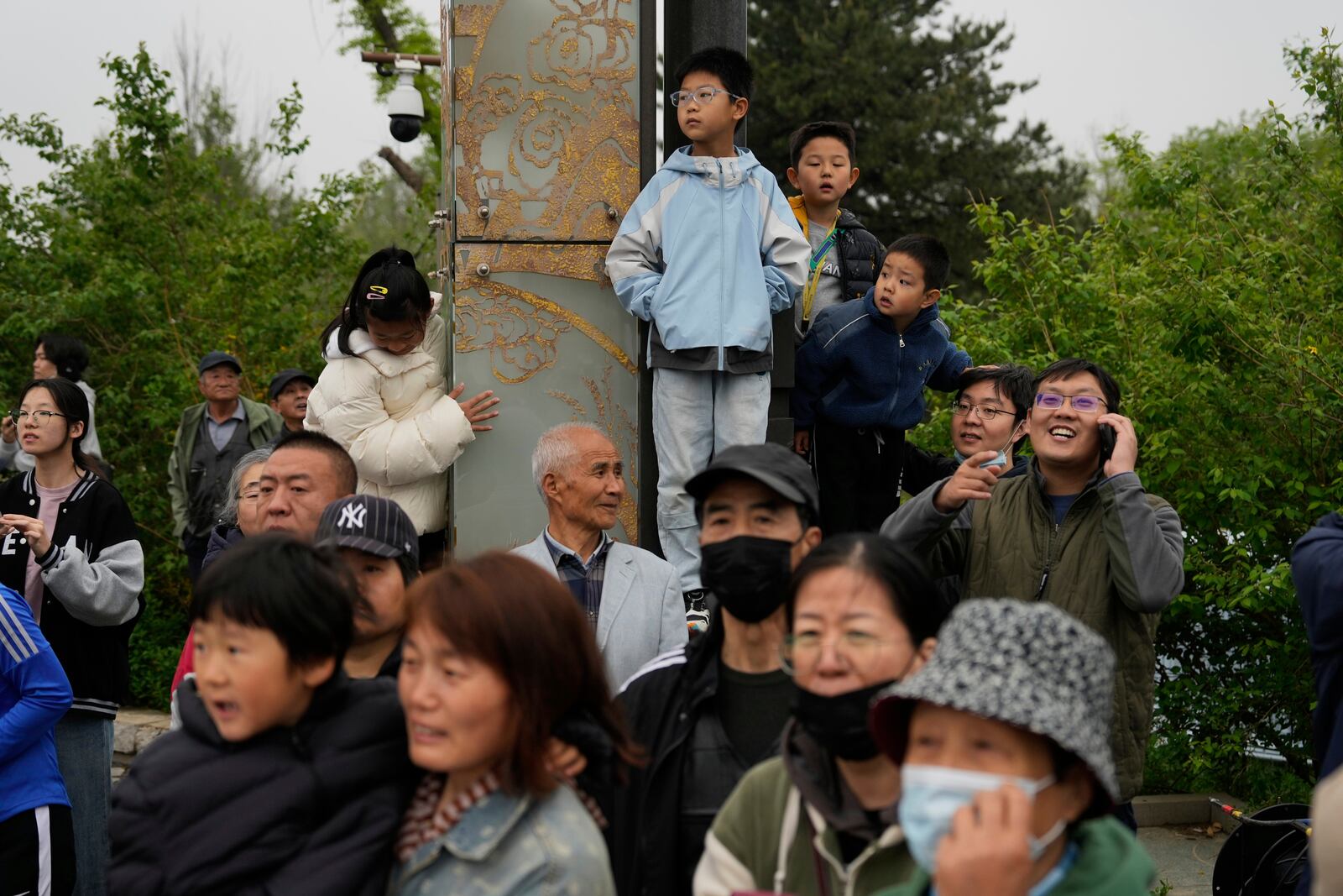 People watch the Humanoid Robot Half-Marathon held in Beijing on Saturday, April 19, 2025. (AP Photo/Ng Han Guan)