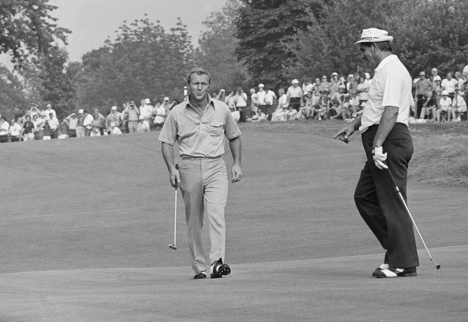 FILE - Arnold Palmer, left, swings his club as he and Julius Boros walk on to green at Oakmont Country Club at Oakmont, Penn., where they were in a four-way tie for the lead in the end of third round of the U.S. Open Golf Championship, June 16, 1973. Palmer, Boros, Jerry Hear and John Schlee all had 3 under 210. (AP Photo/File)