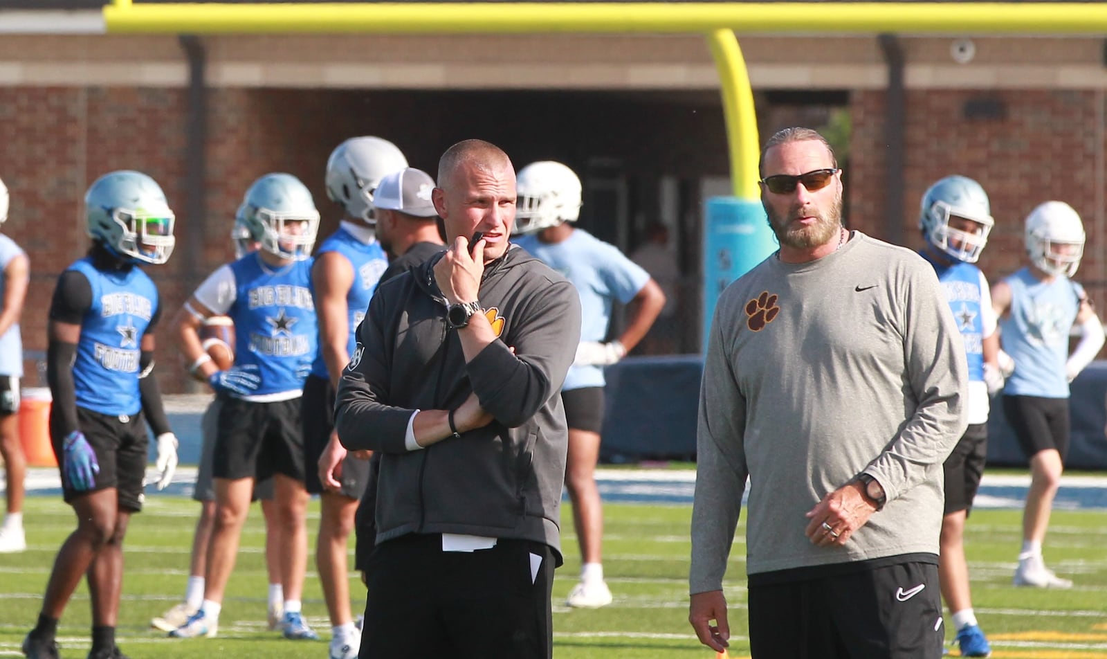 Kenton Ridge coaches Jon Daniels (left) and assistant Tony Broering at a high school football 7 on 7 Fairborn on May 19, 2025.