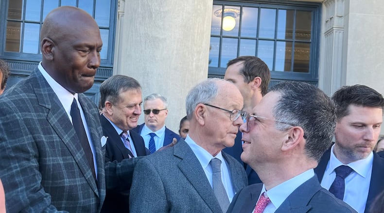 Michael Jordan, left, shakes hands with NASCAR attorney Lawrence Buterman as NASCAR chairman Jim France, center, looks away, Thursday, Dec. 11, 2025, outside the federal courthouse in Charlotte, N.C. (AP Photo/Jenna Fryer)