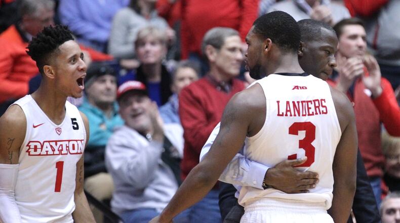 Dayton’s Anthony Grant hugs Trey Landers as Darrell Davis, left, reacts during a game against Virginia Commonwealth on Friday, Jan. 12, 2018, at UD Arena. David Jablonski/Staff